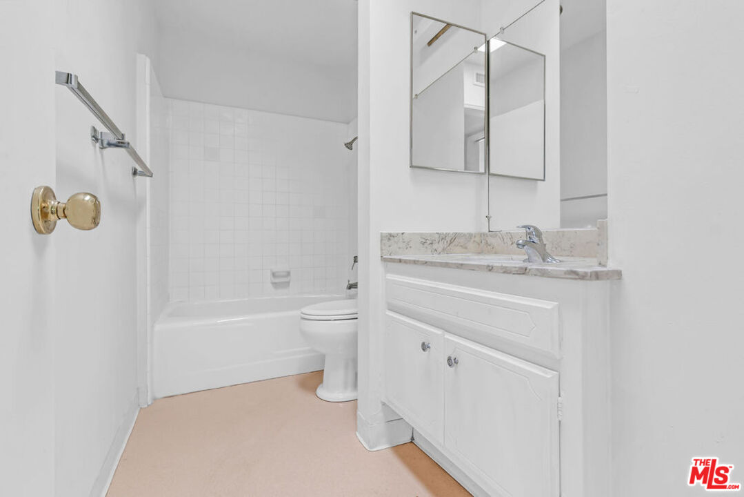 732 Lorraine Boulevard, Unit 5 Los Angeles, CA 90005 - Photo 17 of 25 a bathroom with a granite countertop sink a toilet and bathtub