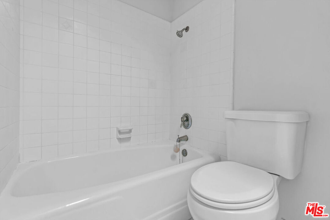 732 Lorraine Boulevard, Unit 5 Los Angeles, CA 90005 - Photo 18 of 25 a white toilet and tub sitting next to a white cabinet
