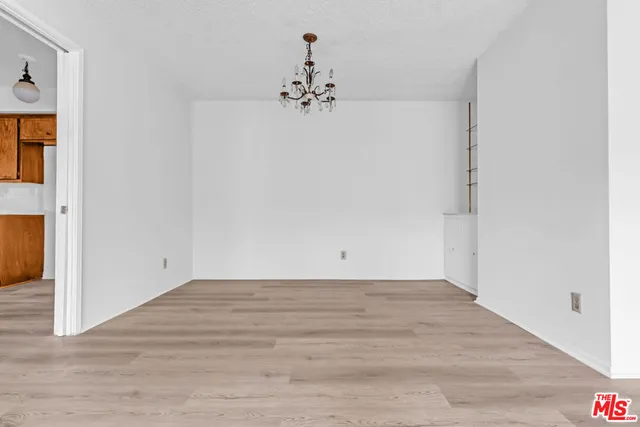 a view of a chandelier in big room with wooden floor