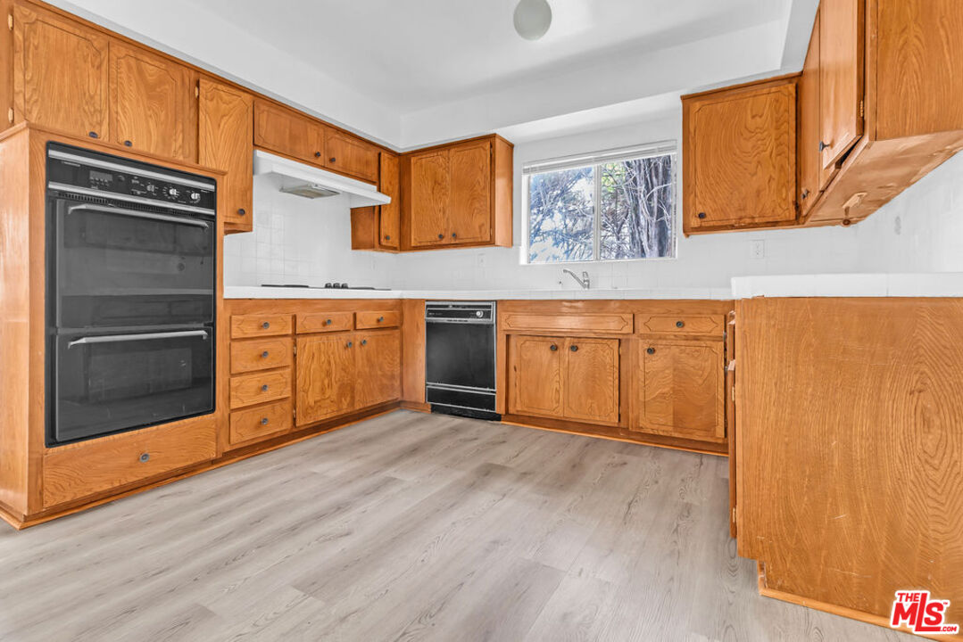 732 Lorraine Boulevard, Unit 5 Los Angeles, CA 90005 - Photo 5 of 25 a kitchen with stainless steel appliances granite countertop a stove a sink and a refrigerator