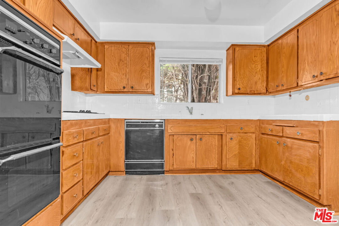 732 Lorraine Boulevard, Unit 5 Los Angeles, CA 90005 - Photo 8 of 25 a kitchen with granite countertop white cabinets and white appliances
