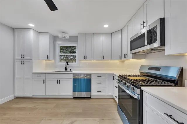 a kitchen with stainless steel appliances a sink stove and microwave