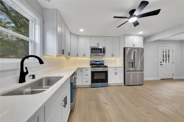 a kitchen with a sink stainless steel appliances and window
