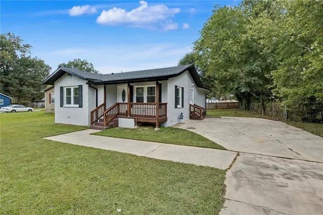 a front view of a house with a yard and trees