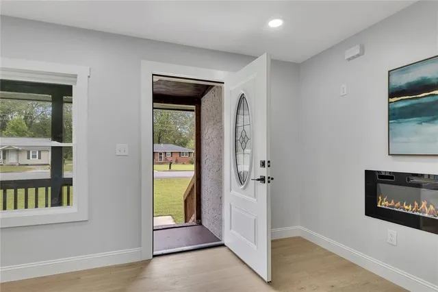a view of a hallway with wooden floor and a living room