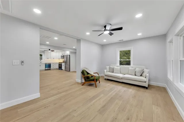 a living room with furniture and a ceiling fan