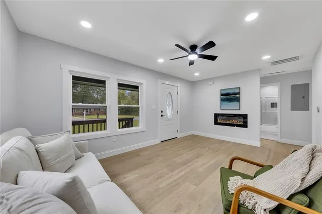 a living room with furniture ceiling fan and a window