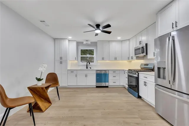 a kitchen with a refrigerator cabinets and wooden cabinets
