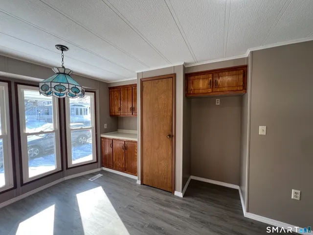 a view of a hallway with wooden floor and chandelier