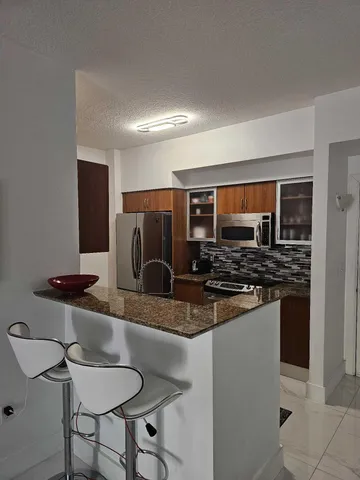 a kitchen with stainless steel appliances granite countertop a stove and a refrigerator
