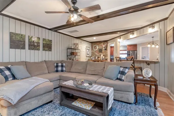 a living room with furniture a ceiling fan and a rug