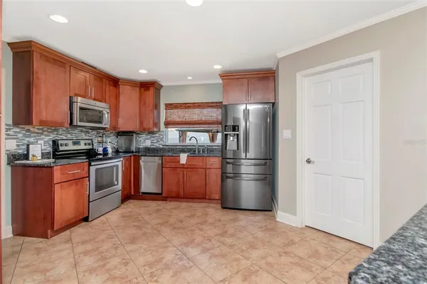 a kitchen with stainless steel appliances granite countertop a refrigerator and a stove top oven