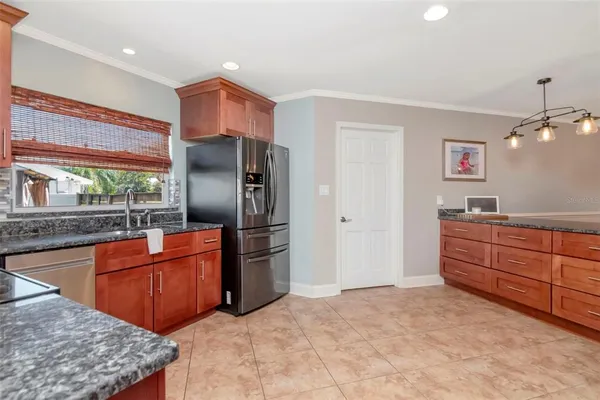 a kitchen with stainless steel appliances granite countertop a refrigerator and a sink