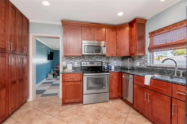 a kitchen with stainless steel appliances granite countertop wooden cabinets stove top oven and sink