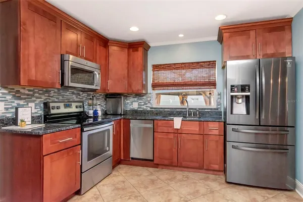 a kitchen with stainless steel appliances granite countertop a refrigerator stove top oven