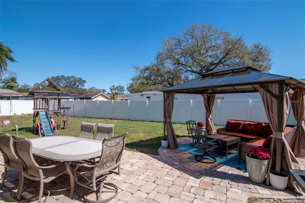 a view of a patio with table and chairs under an umbrella