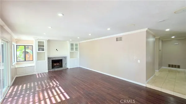 a view of empty room with wooden floor and fireplace
