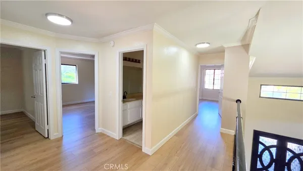 a view of a hallway with wooden floor and stairs