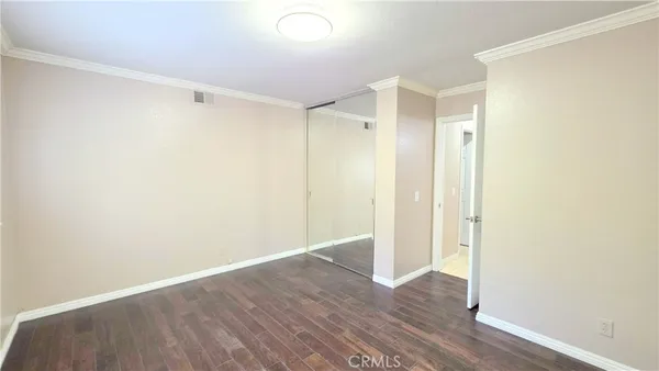 a view of an empty room with wooden floor