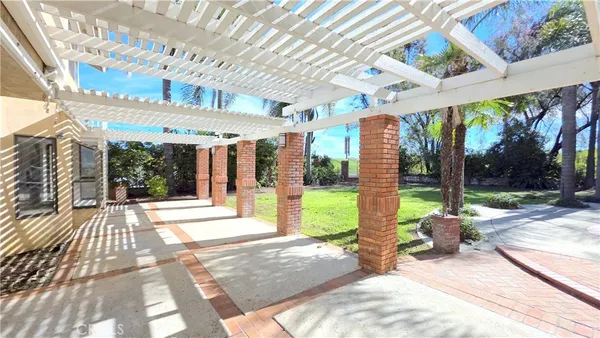 a view of a patio with table and chairs potted plants with floor to ceiling window