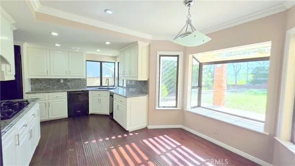 a open kitchen with granite countertop a stove top oven sink and cabinets