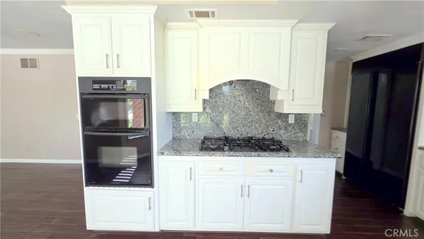a kitchen with granite countertop a refrigerator and a stove
