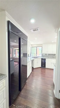a view of a kitchen with wooden floor and a refrigerator