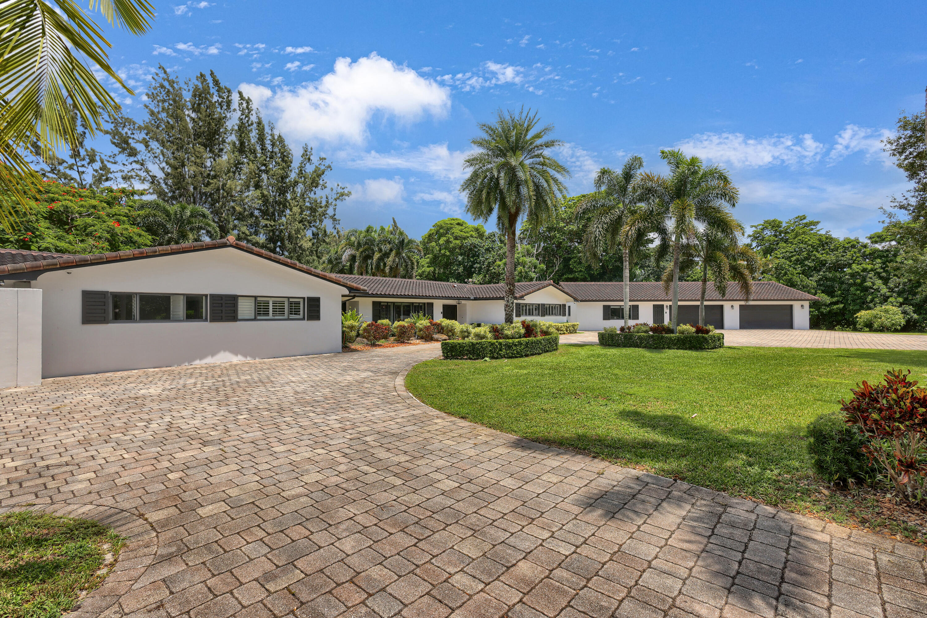 14701 Southwest 63rd Street Southwest Ranches, FL 33330 - Photo 2 of 47 a front view of a house with a yard and palm trees