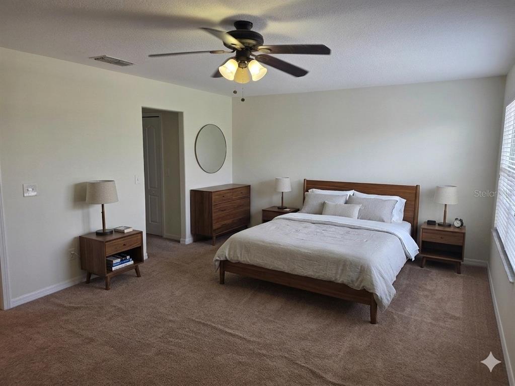 3158 Rodrick Circle Orlando, FL 32824 - Photo 11 of 17 a bedroom with a bed a chandelier and a lamp on dresser