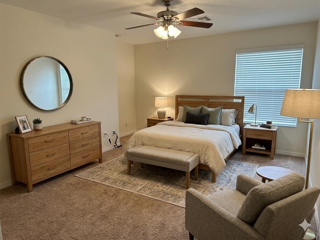 3158 Rodrick Circle Orlando, FL 32824 - Photo 13 of 17 a bedroom with a bed a mirror on dresser and a chandelier