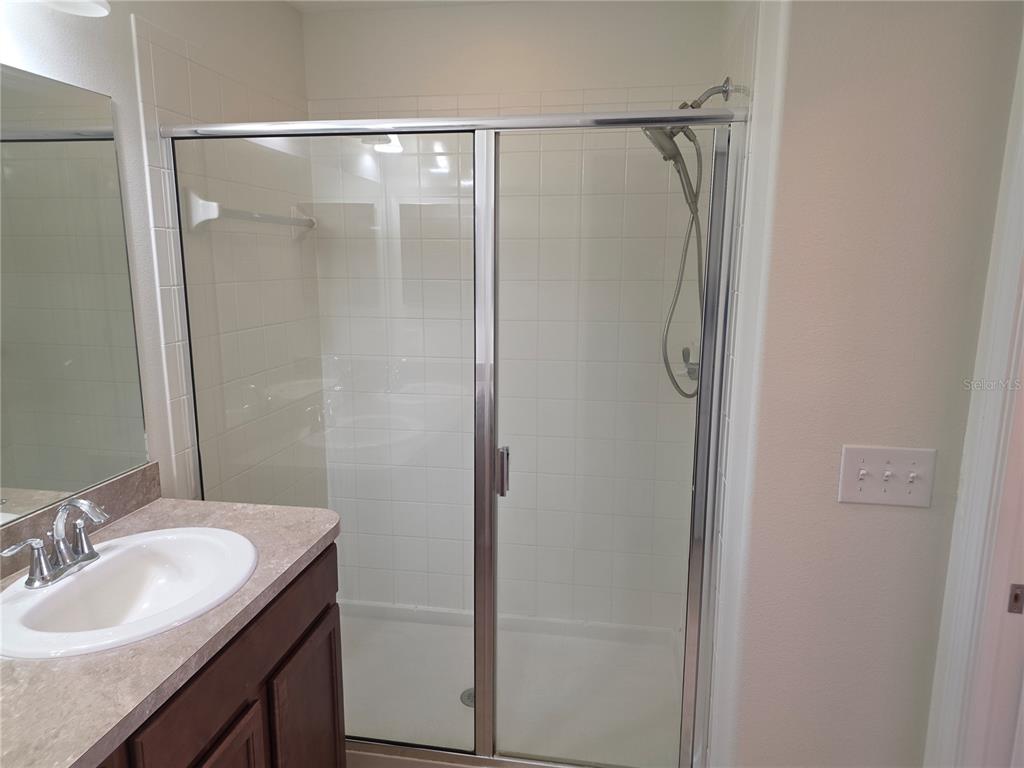 3158 Rodrick Circle Orlando, FL 32824 - Photo 17 of 17 a bathroom with a granite countertop shower sink vanity and a mirror