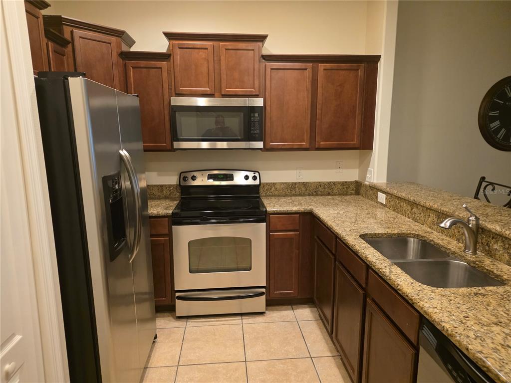 3158 Rodrick Circle Orlando, FL 32824 - Photo 6 of 17 a kitchen with stainless steel appliances granite countertop a refrigerator stove and sink