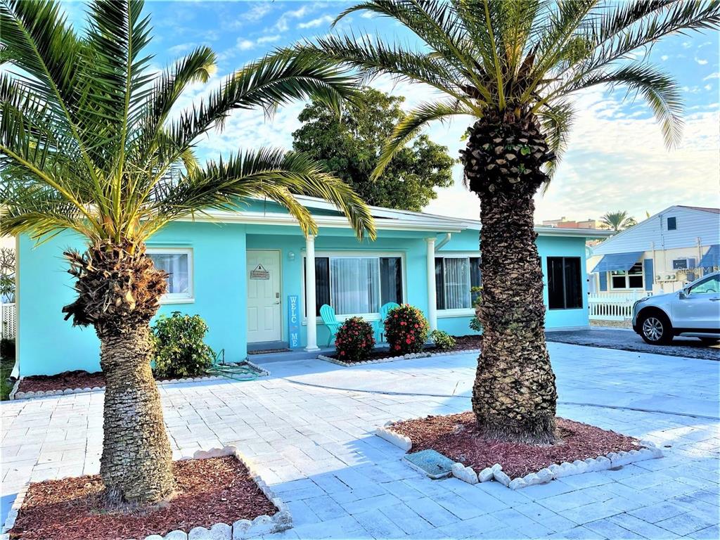 113 174th Avenue East Redington Shores, FL 33708 - Photo 2 of 16 a front view of a house with garden and trees