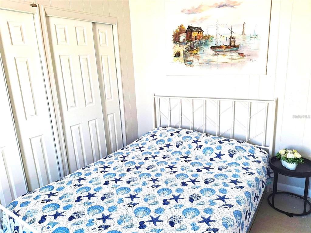113 174th Avenue East Redington Shores, FL 33708 - Photo 7 of 16 a bedroom with a bed and a painting on the wall