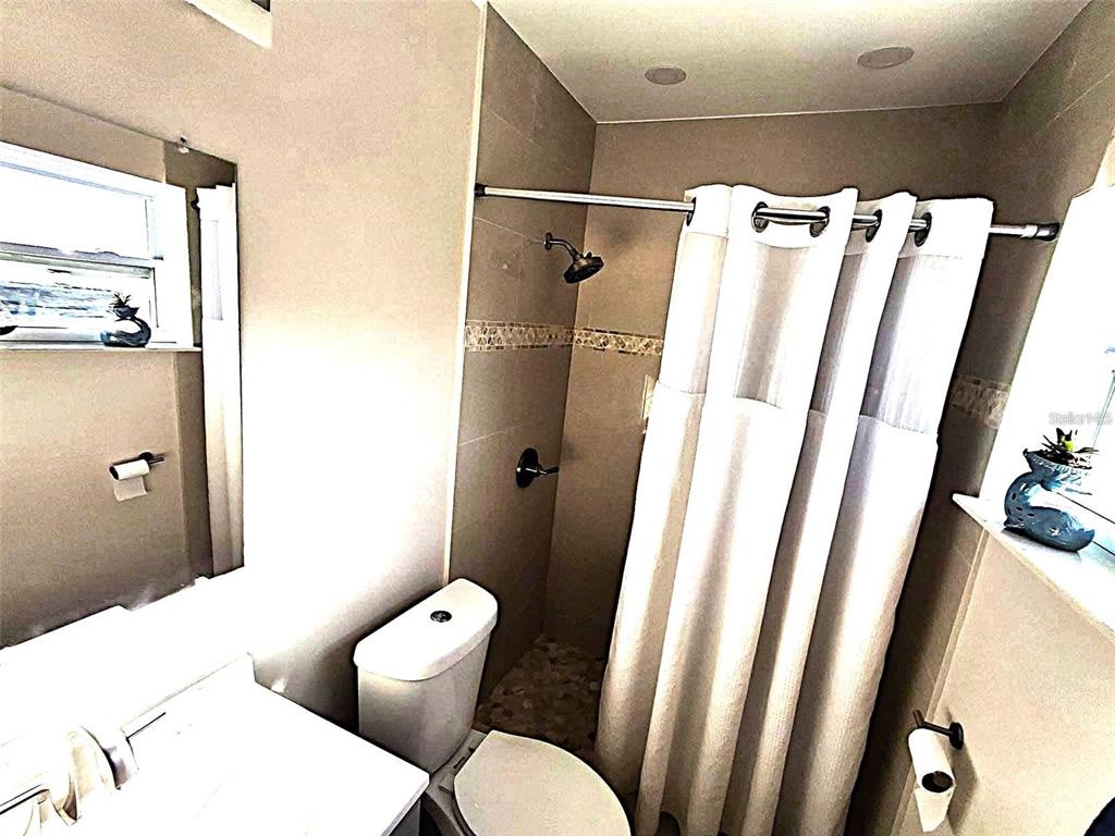 113 174th Avenue East Redington Shores, FL 33708 - Photo 9 of 16 a white toilet sitting next to a bathroom sink and a shower