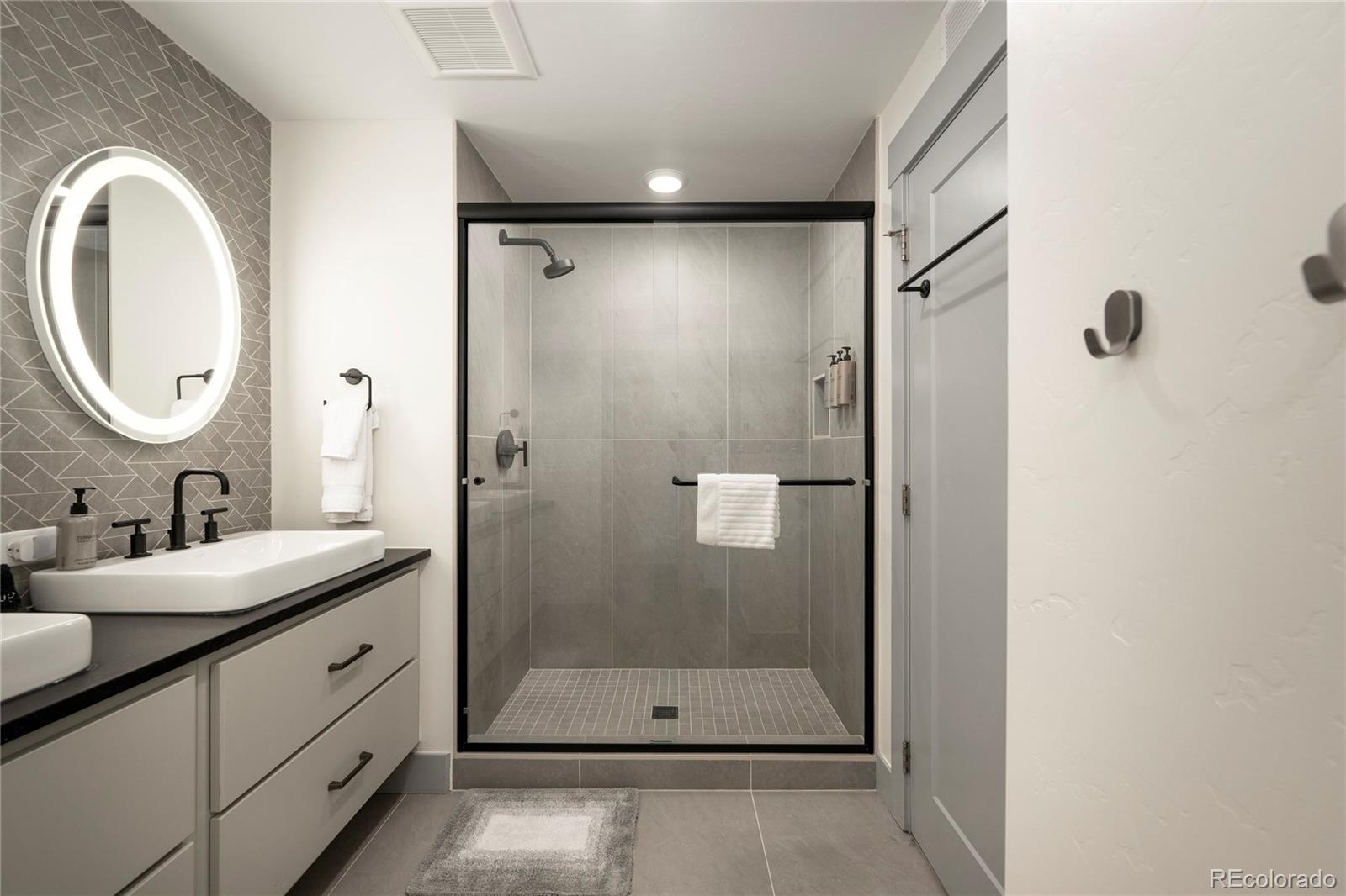 144 Ski Idlewild Road, Unit 2203 Winter Park, CO 80482 - Photo 30 of 45 a bathroom with a double vanity sink mirror and shower