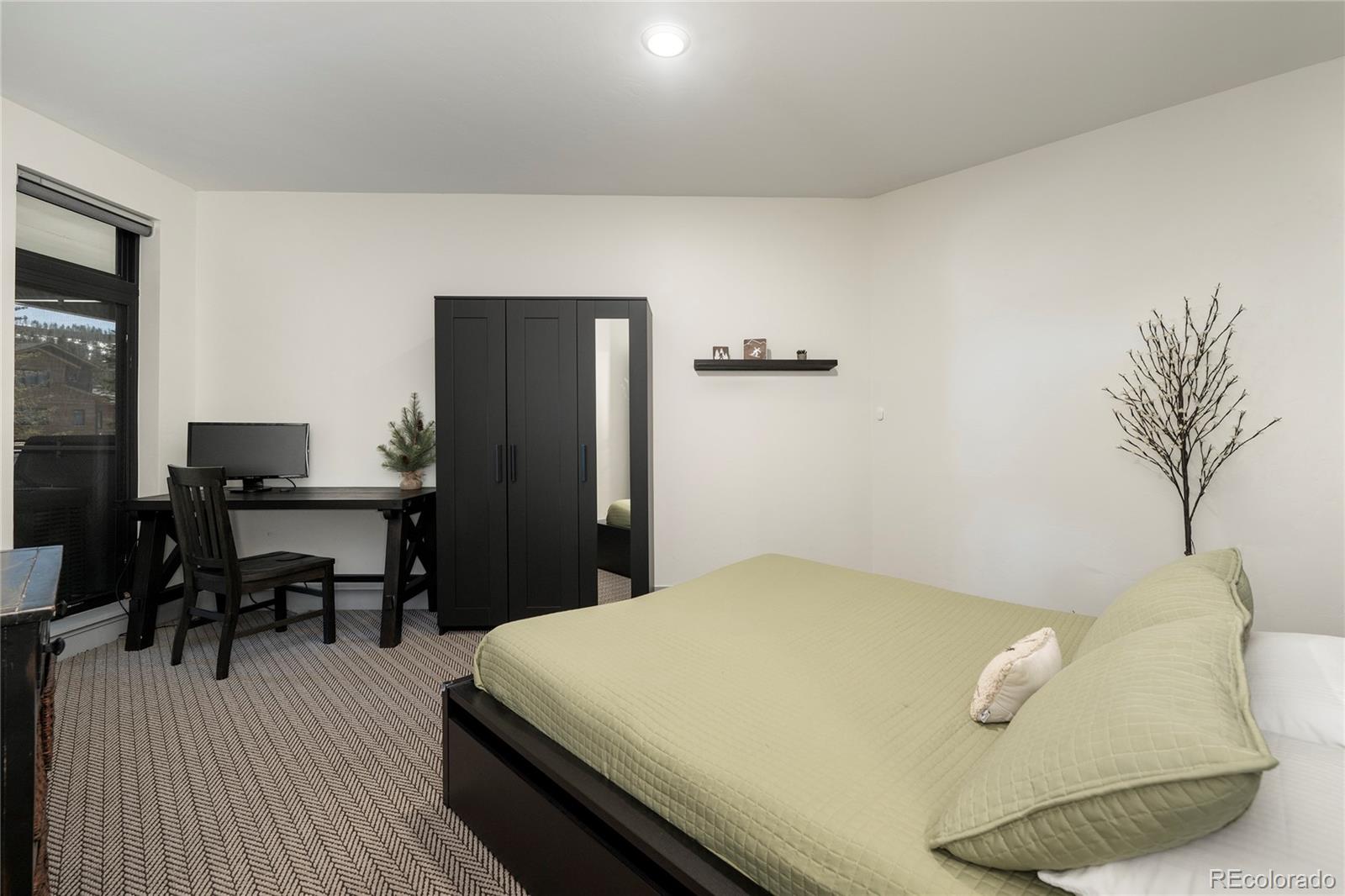 144 Ski Idlewild Road, Unit 2203 Winter Park, CO 80482 - Photo 31 of 45 a bedroom with a bed and a table in it
