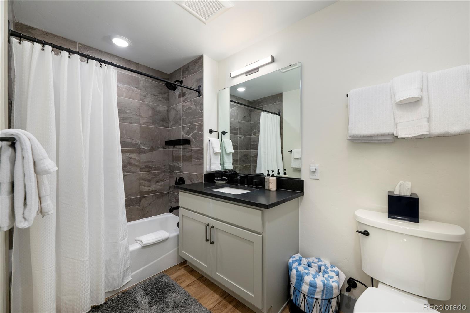 144 Ski Idlewild Road, Unit 2203 Winter Park, CO 80482 - Photo 34 of 45 a bathroom with a granite countertop sink a toilet and a shower