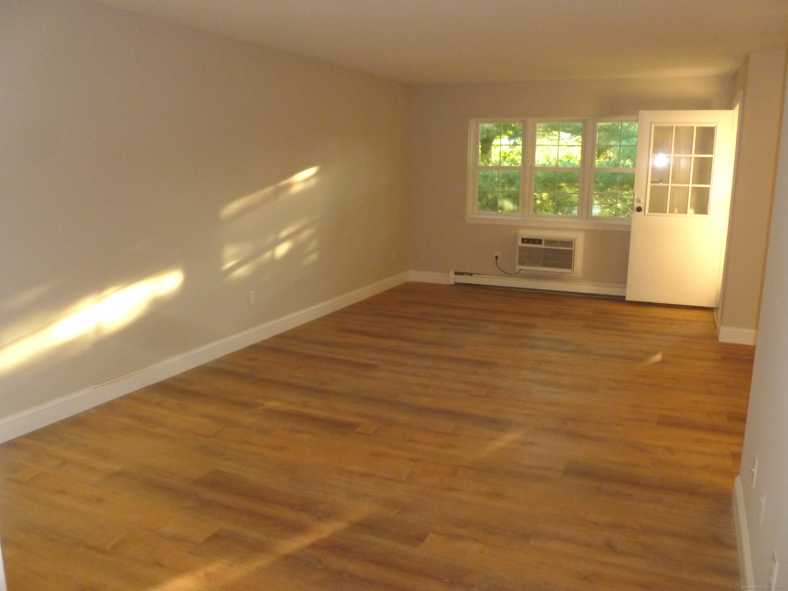 2955 Madison Avenue, Unit 46 Bridgeport, CT 06606 - Photo 11 of 29 a view of wooden floor and windows in a room