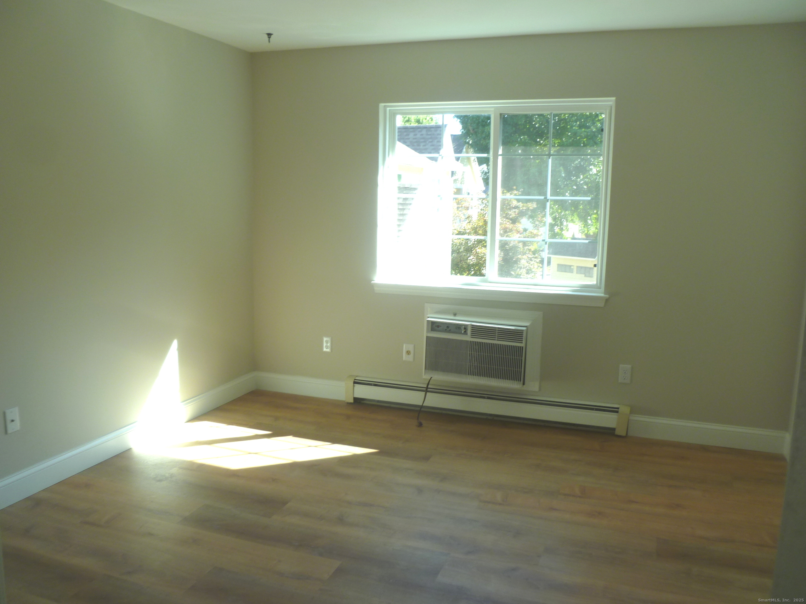2955 Madison Avenue, Unit 46 Bridgeport, CT 06606 - Photo 17 of 29 an empty room with wooden floor and windows