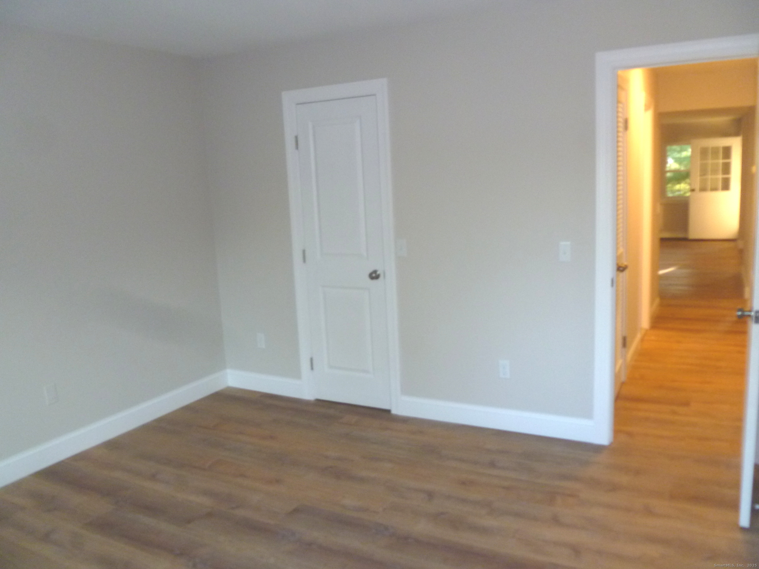 2955 Madison Avenue, Unit 46 Bridgeport, CT 06606 - Photo 19 of 29 a view of an empty room with wooden floor and a window