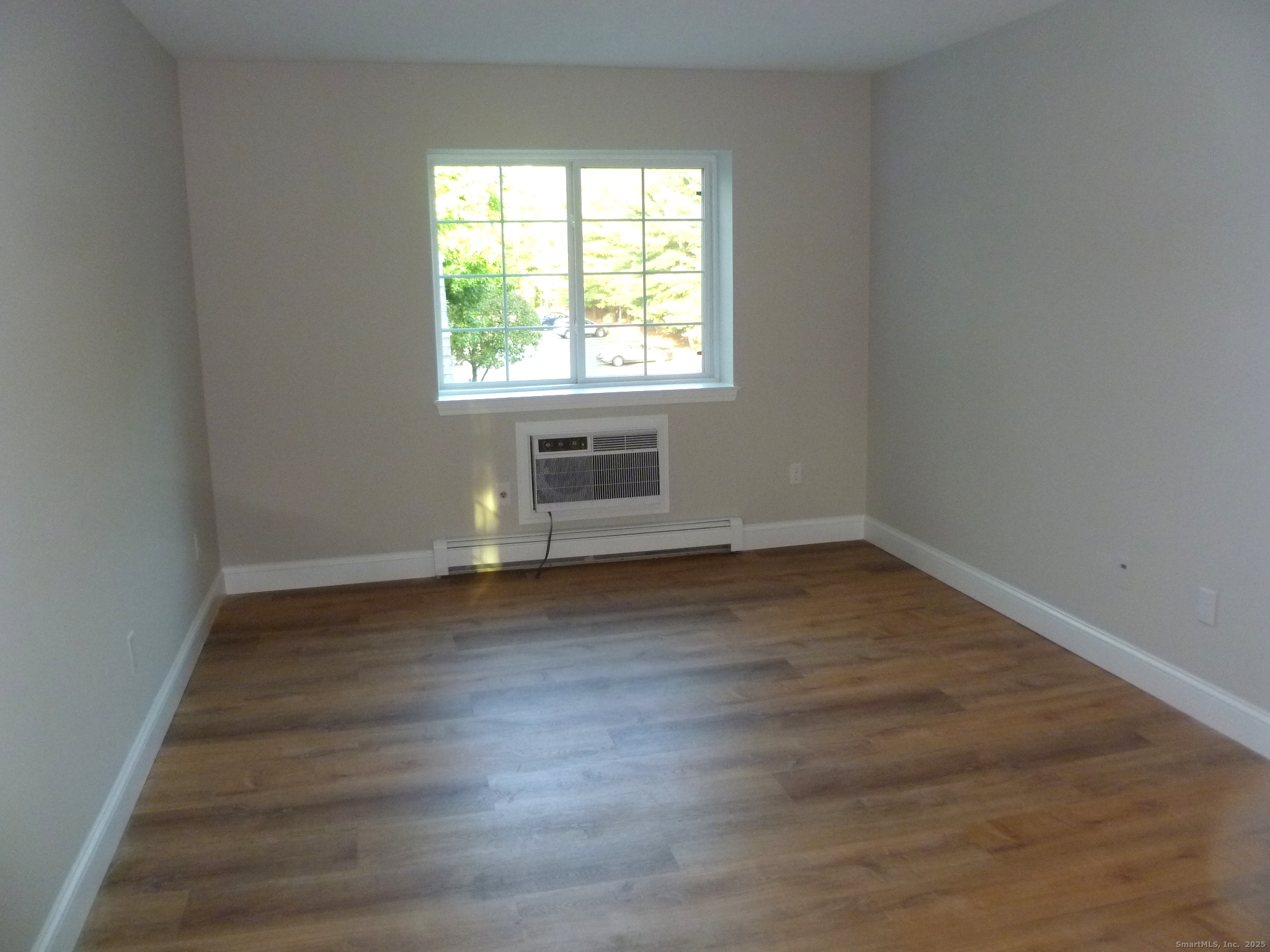 2955 Madison Avenue, Unit 46 Bridgeport, CT 06606 - Photo 21 of 29 an empty room with wooden floor and windows