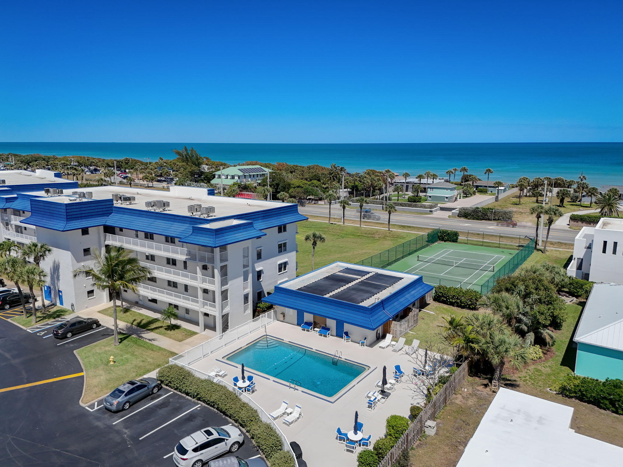an aerial view of a building with swimming pool and ocean view