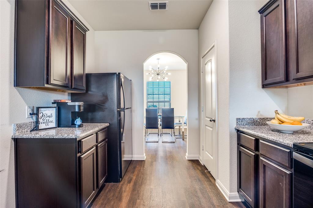 14240 Chaps Drive Dallas, TX 75253 - Photo 10 of 25 a kitchen with stainless steel appliances granite countertop a refrigerator a sink dishwasher a stove and a dining table with wooden floor