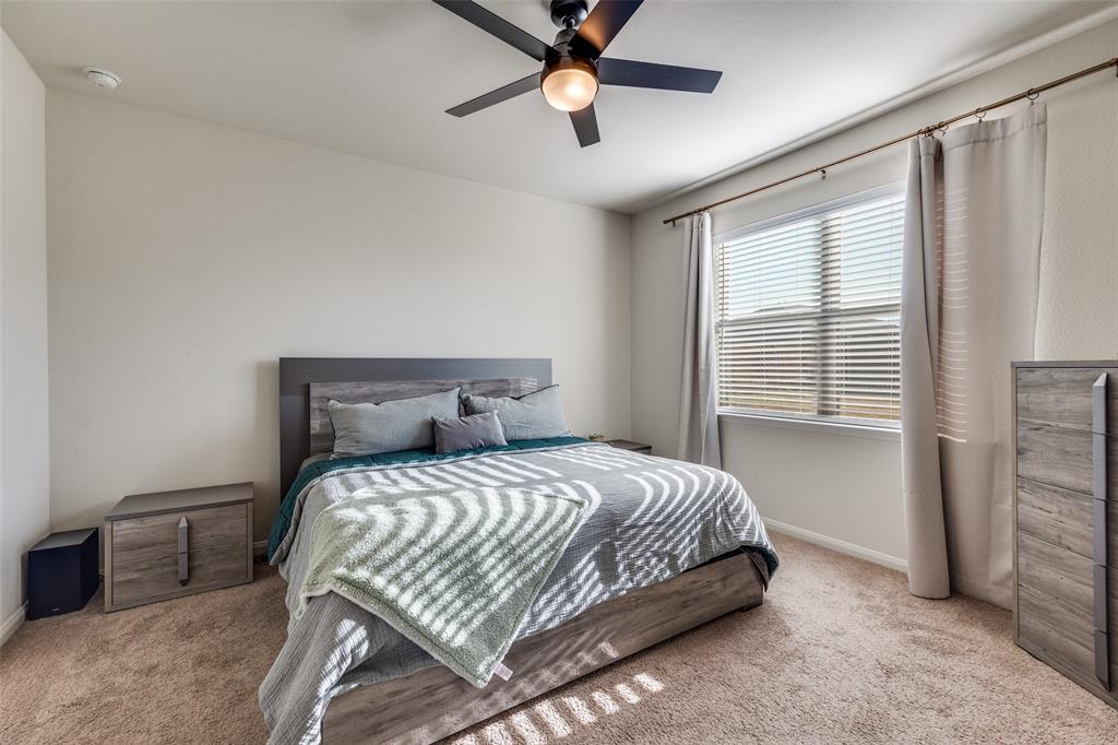 14240 Chaps Drive Dallas, TX 75253 - Photo 13 of 25 a bedroom with a bed and a chandelier