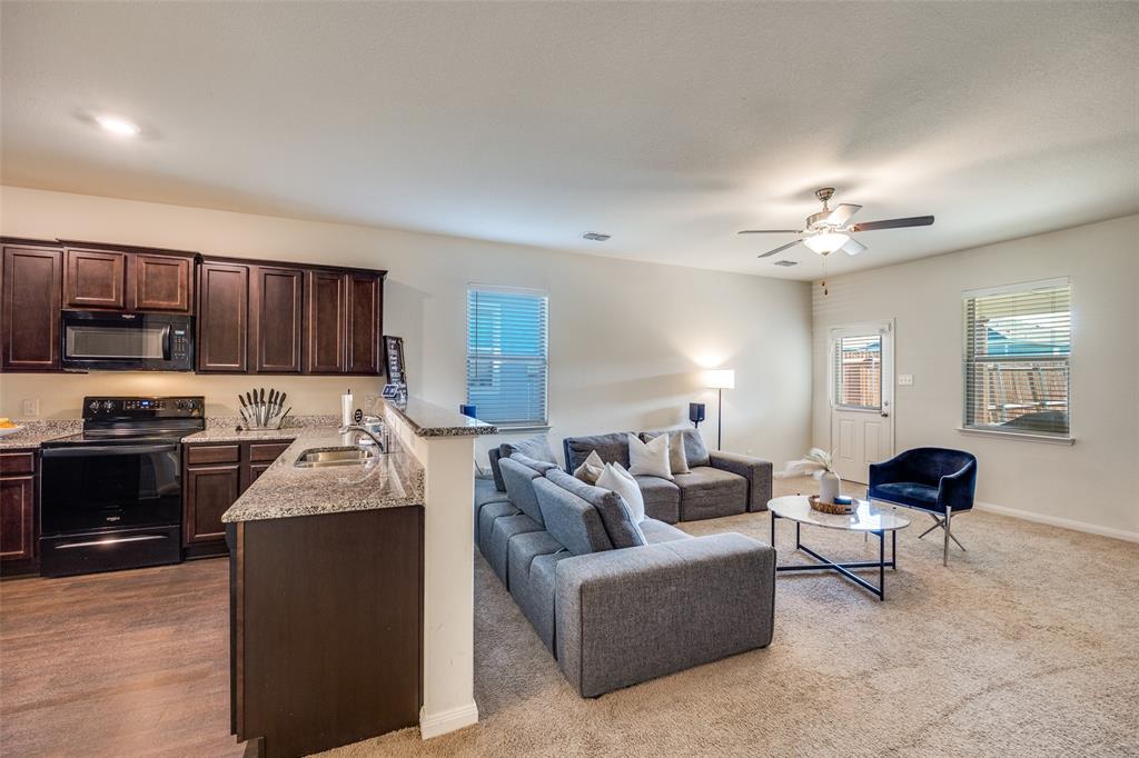 14240 Chaps Drive Dallas, TX 75253 - Photo 7 of 25 a living room with furniture a lamp and kitchen view