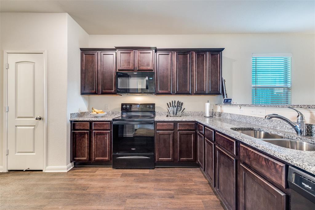 14240 Chaps Drive Dallas, TX 75253 - Photo 9 of 25 a kitchen with stainless steel appliances granite countertop a sink stove and cabinets