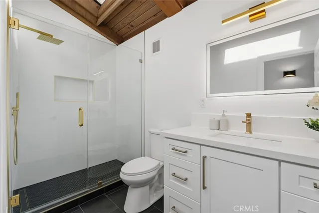 a bathroom with a granite countertop sink a toilet and a mirror