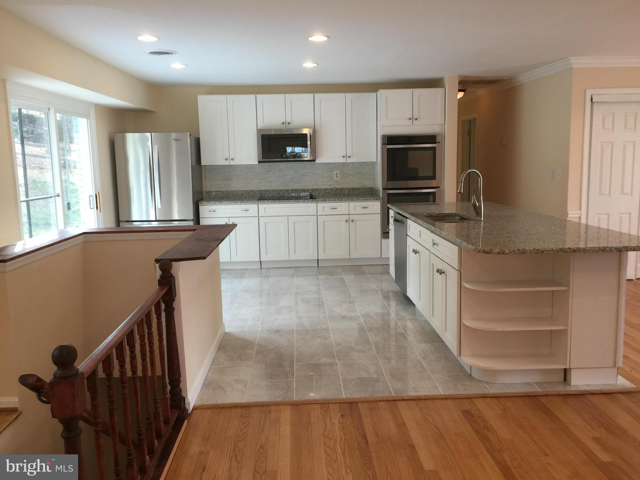 23813 Stringtown Road Clarksburg, MD 20871 - Photo 3 of 12 a large kitchen with stainless steel appliances granite countertop a stove top oven a sink dishwasher a refrigerator and cabinets with wooden floor