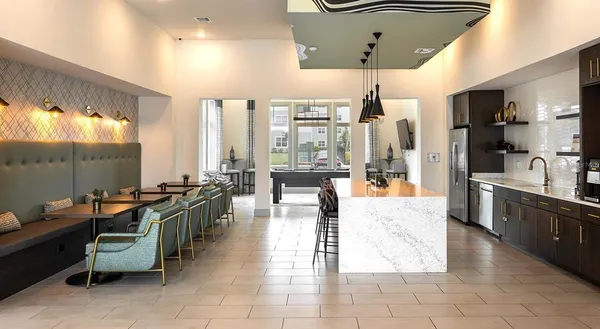 a large living room with kitchen island stainless steel appliances furniture a large window and a sink